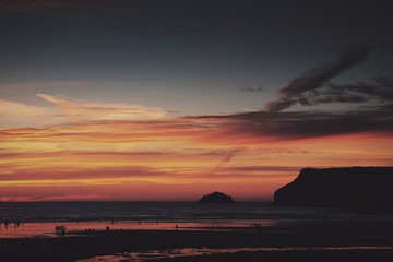 Fototapeta na wymiar Colourful sunset over the beach at Polzeath Vintage Retro Filter