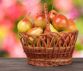 pears in a wicker basket on  wooden table with  blurred background