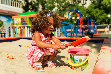 Little cute girl playing in sandbox