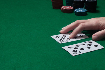 two cards of the player's hand at the game table with chips