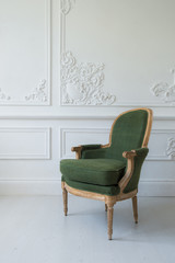 One classic armchair against a white wall and floor. Copy space