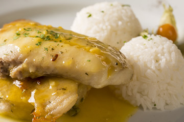 fried tilapia served with rice on white plate.