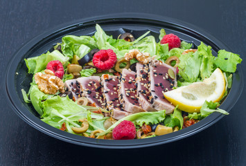 tuna sashimi with fresh salad with raspberry, nut and green olives