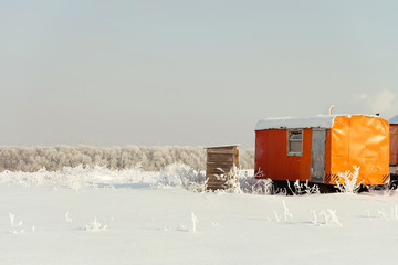 Construction trailer left in the snow. Caravan in winter field. Site container.