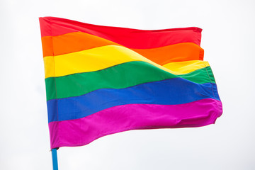 Rainbow flag (LGBT movement) waving high on the sky