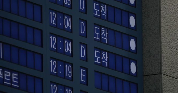 Flight schedule in several languages displaying the time of arrived airplanes