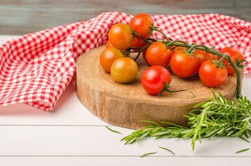 Organic cherry tomatoes with rosemary on rustic wooden table