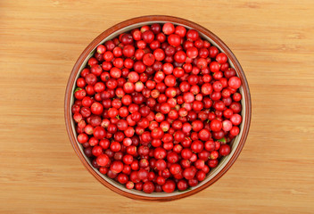 Lingonberry (Vaccinium vitis-idaea) in dish on wooden background