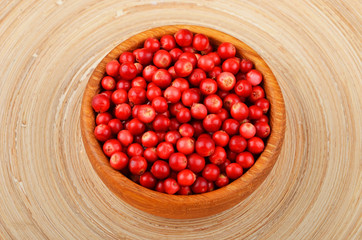 Lingonberry (Vaccinium vitis-idaea) in dish on wooden background