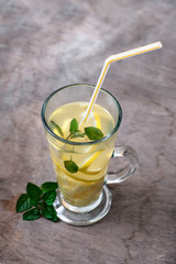 Ginger tea with lemon, ginger root and mint on rustic background