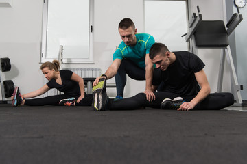 Group Of Smiling People Exercising In The Gym