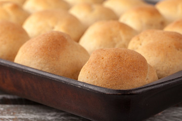 Fresh homemade whole wheat dinner rolls on an old weathered barn wood table