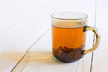 cup of hot tea on a light wooden background