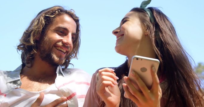 Couple laughing and watching smartphone 