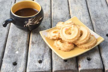 stack of fresh butter cookies in plate and hot coffee