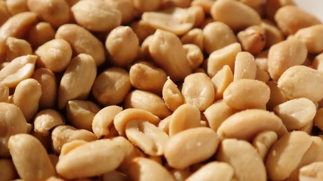 In a bowl served tasty groundnut snack food slow tilting background 4K 2160p UltraHD video - Salted and roasted snack Arachis hypogaea peanuts pile 4K 3840X2160 UHD tilt footage 