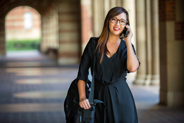 Pretty female college scholar student professional attire fashionable on campus phone call