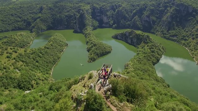 Aerial: people arriving at viewpoint over beautiful Uvac lake in Serbia.
