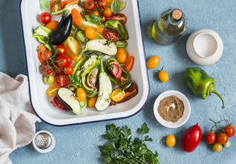 Raw ingredients for lunch - fresh chopped vegetables in the pan on a blue background, top view. Healthy vegetarian food
