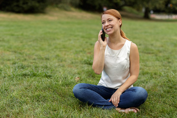 Caucasian woman in city park talking on cell phone