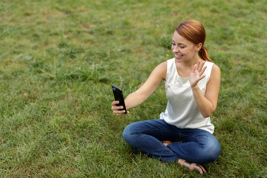 Caucasian woman in city park video chat selfie cell phone