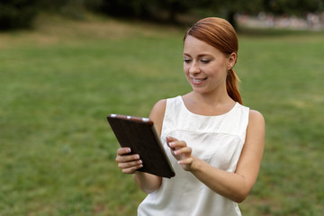 Caucasian woman in city park using tablet computer