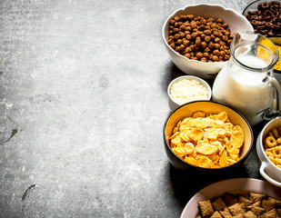 Cereal and a jug of milk. On stone table.