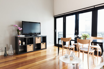 Modern apartment living room with bi fold door to balcony