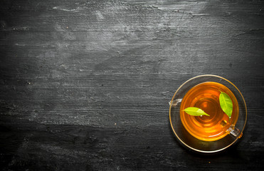 Cup of tea with green leaves.