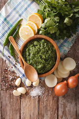 Argentine chimichurri spicy sauce and ingredients close-up. vertical top view
