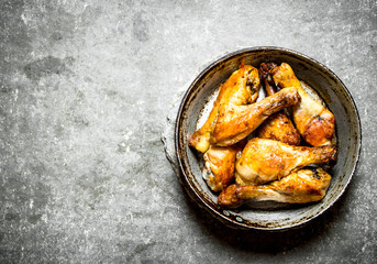 Fried chicken legs on the old pan.