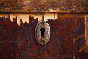 Rusty keyhole in old wooden wardrobe