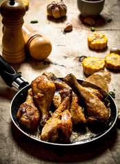 Fried chicken legs with corn and garlic.