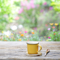 yellow mug and wooden spoon on wooden table