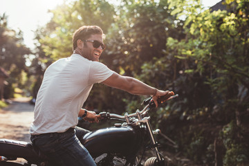 Fototapeta premium Przystojny młody człowiek na motocyklu