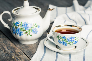 still life with tea cup and tablecloth on wooden table