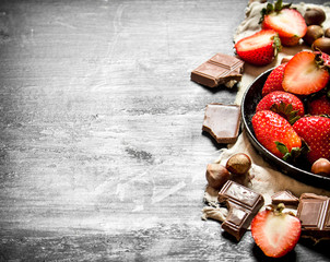 Strawberries with slices of chocolate and nuts.