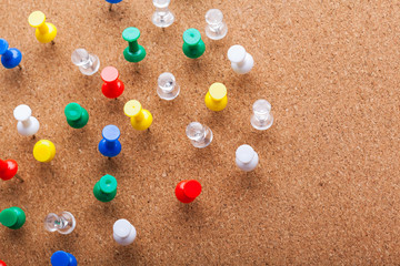 Group of thumbtacks pinned on corkboard