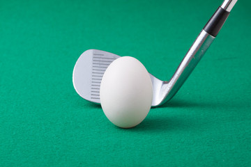 卵のボールとゴルフクラブ(アイアン)