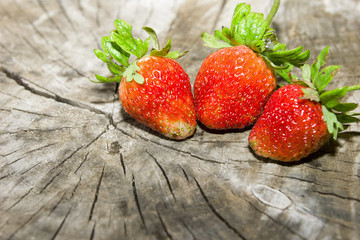 Freshly picked from the garden strawberry on a natural wooden cutting closeup with copy space