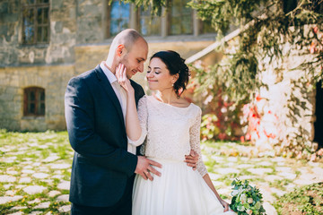 Fototapeta premium Stylish happy wedding couple on the background beautiful old castle