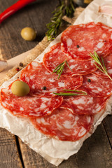 Chorizo sausage and salami, thin cut. spanish salami on the wood background with spices, paprika, pepper. Spicy food. Chili.