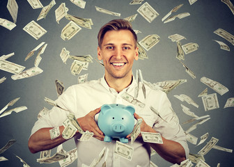 man with piggy bank under money rain falling down dollar bills