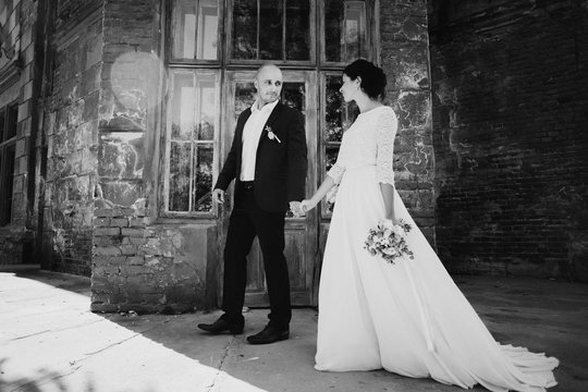 Stylish happy wedding couple on the background beautiful old castle. Romantic newlywed groom and bride.