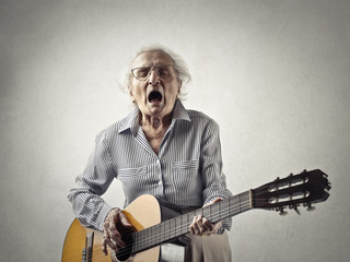 Grandmother playing the guitar - obrazy, fototapety, plakaty