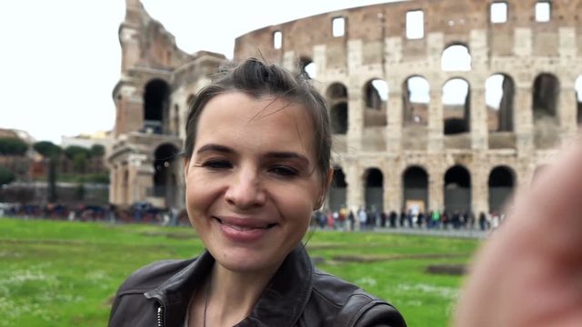 Happy woman taking selfie photo and recording video near Colosseum, super slow motion 240fps
