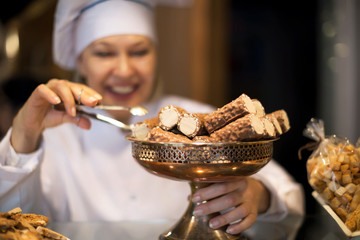Mature bakery employee working in bakery with different pastry