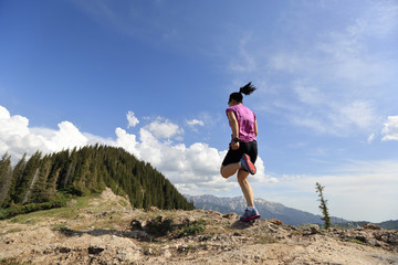 Naklejka premium healthy lifestyle woman trail runner running on beautiful mountain peak