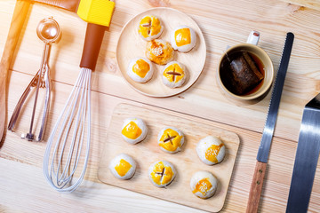 Chinese pastries with a cup of tea and baking utensils on wood table