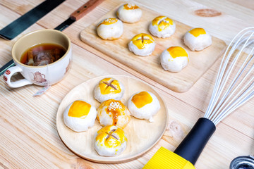 Chinese pastries with a cup of tea and baking utensils on wood table